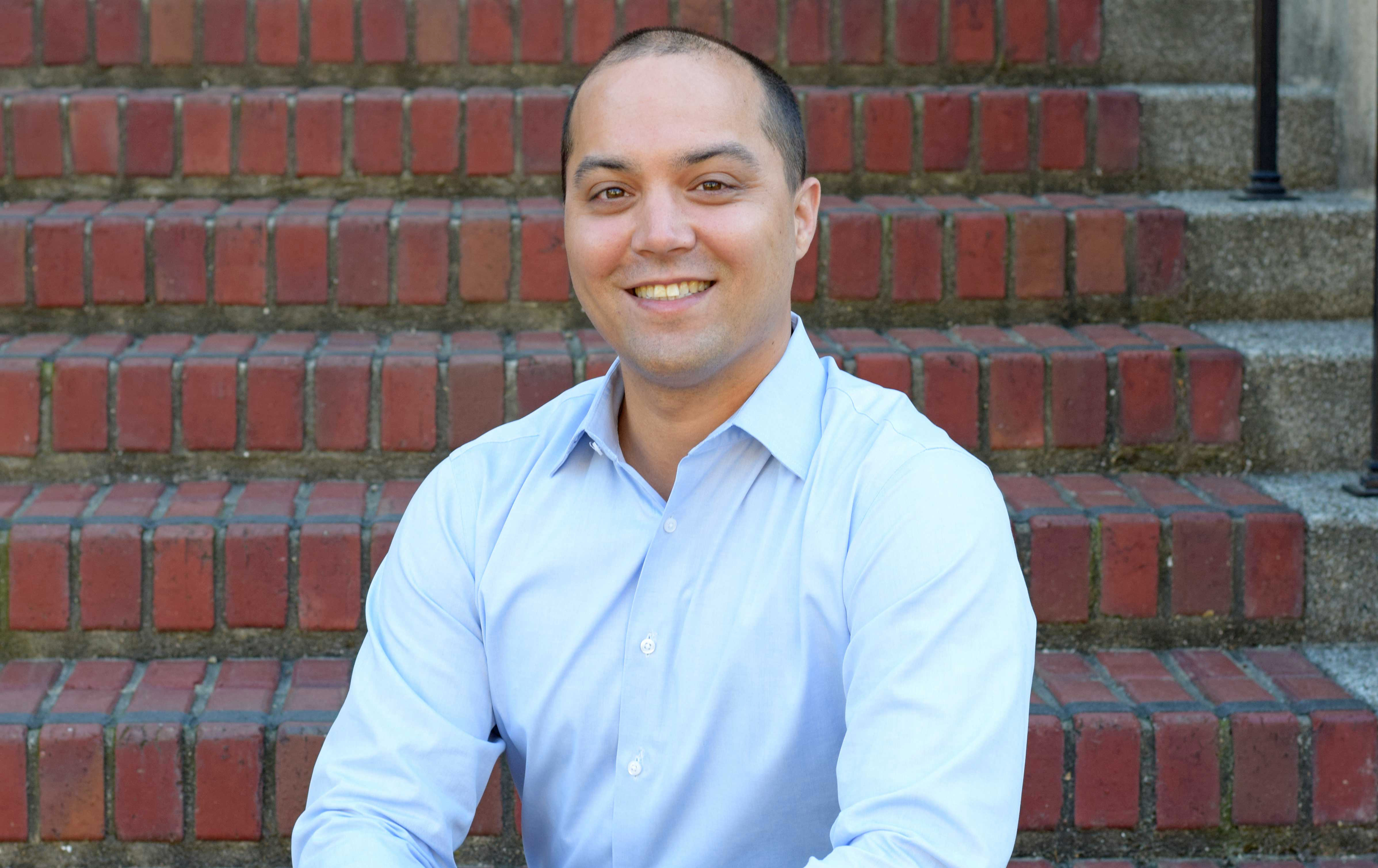 James Olzmann sits on a brick staircase