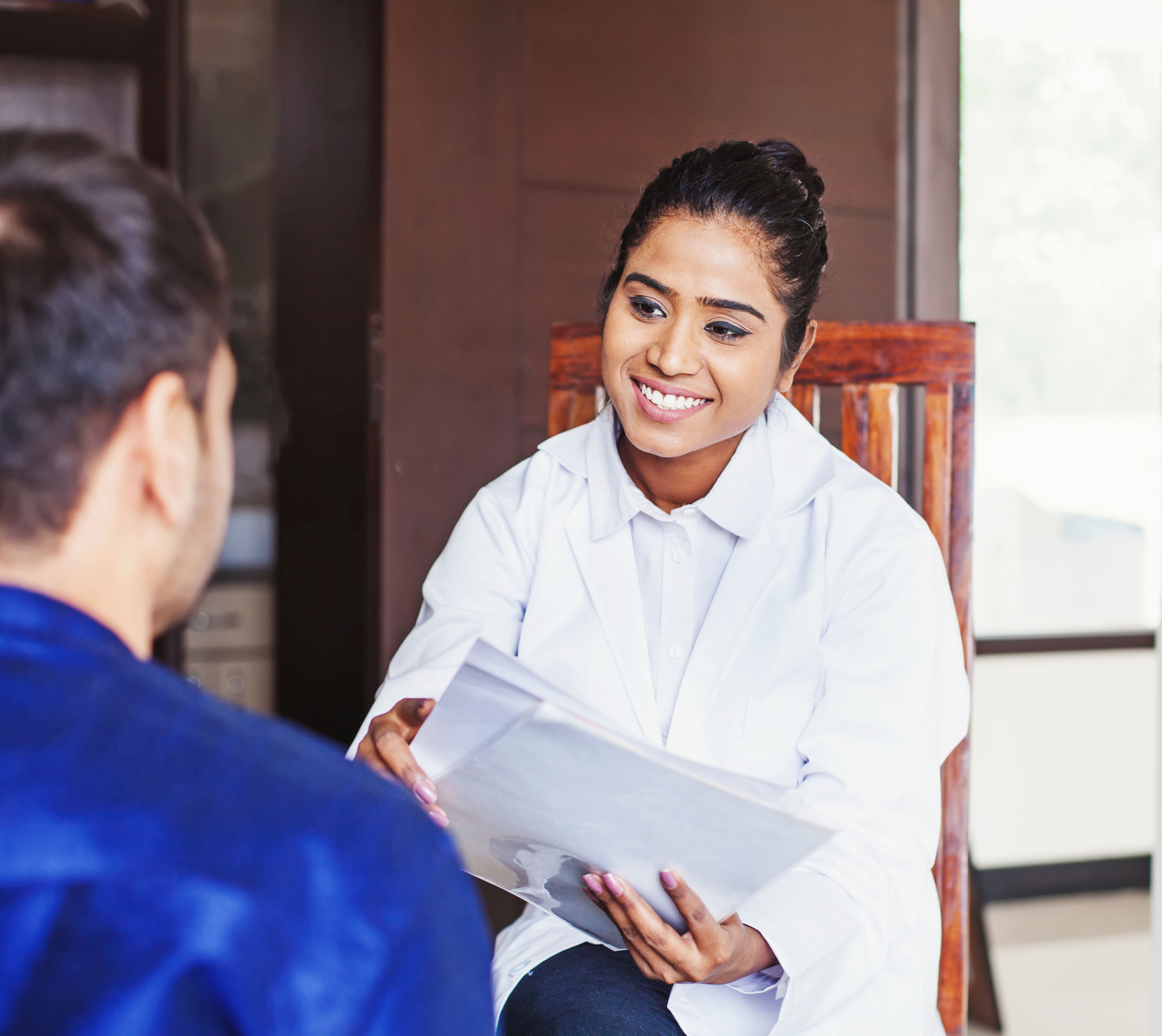 A dietitian in a white coat smiling at a client