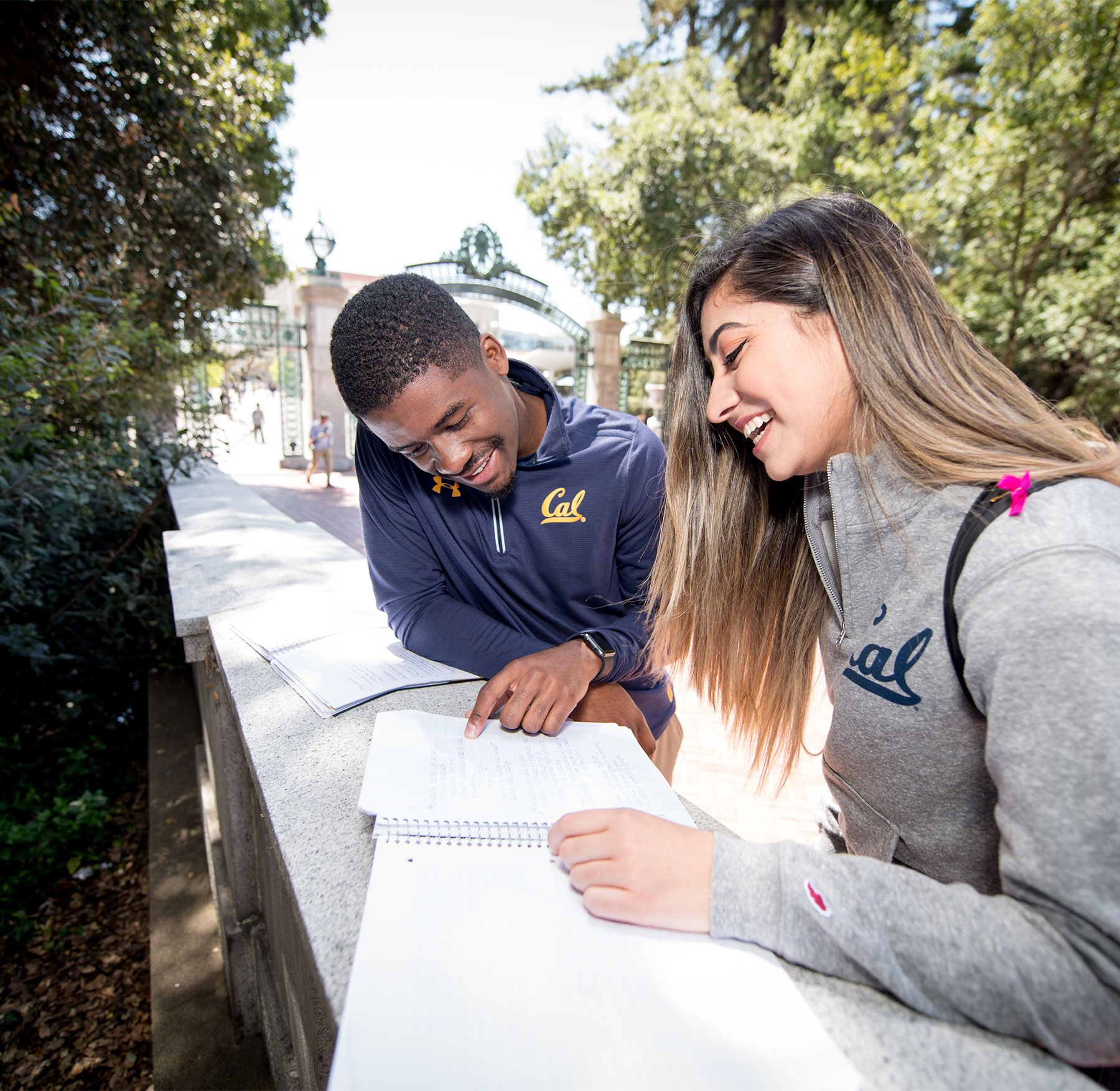 Two students looking at a notebook outside on the UC Berkeley campus